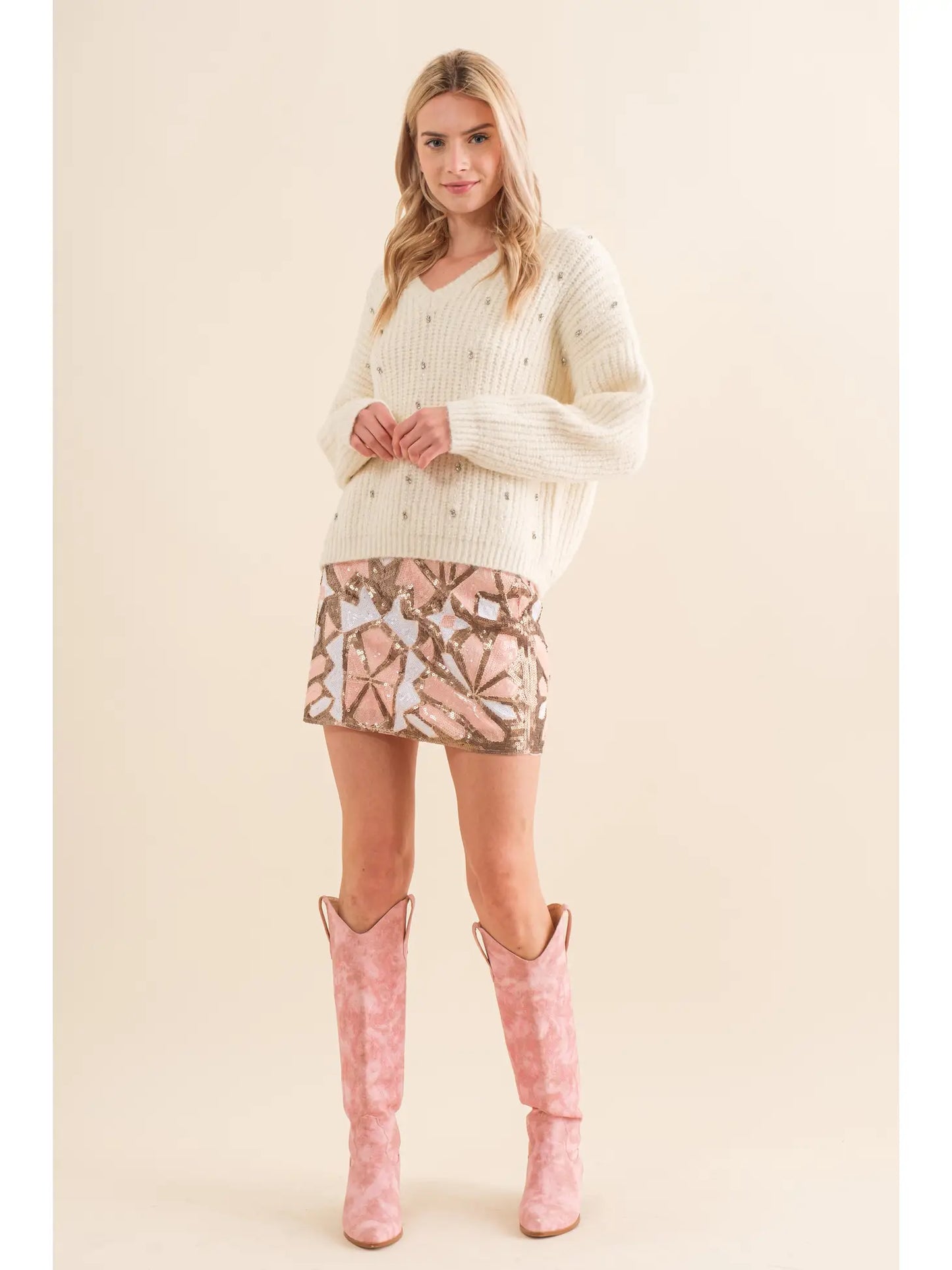 Geo Pattern Sequin Multi Color (pink, gold and white))Mini Skirt paired with a ivory sweater with silver details and cowboy boots