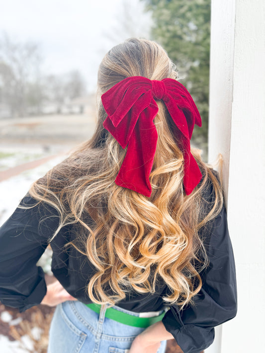 back view of woman wearing big red velvet bow barette in her hair