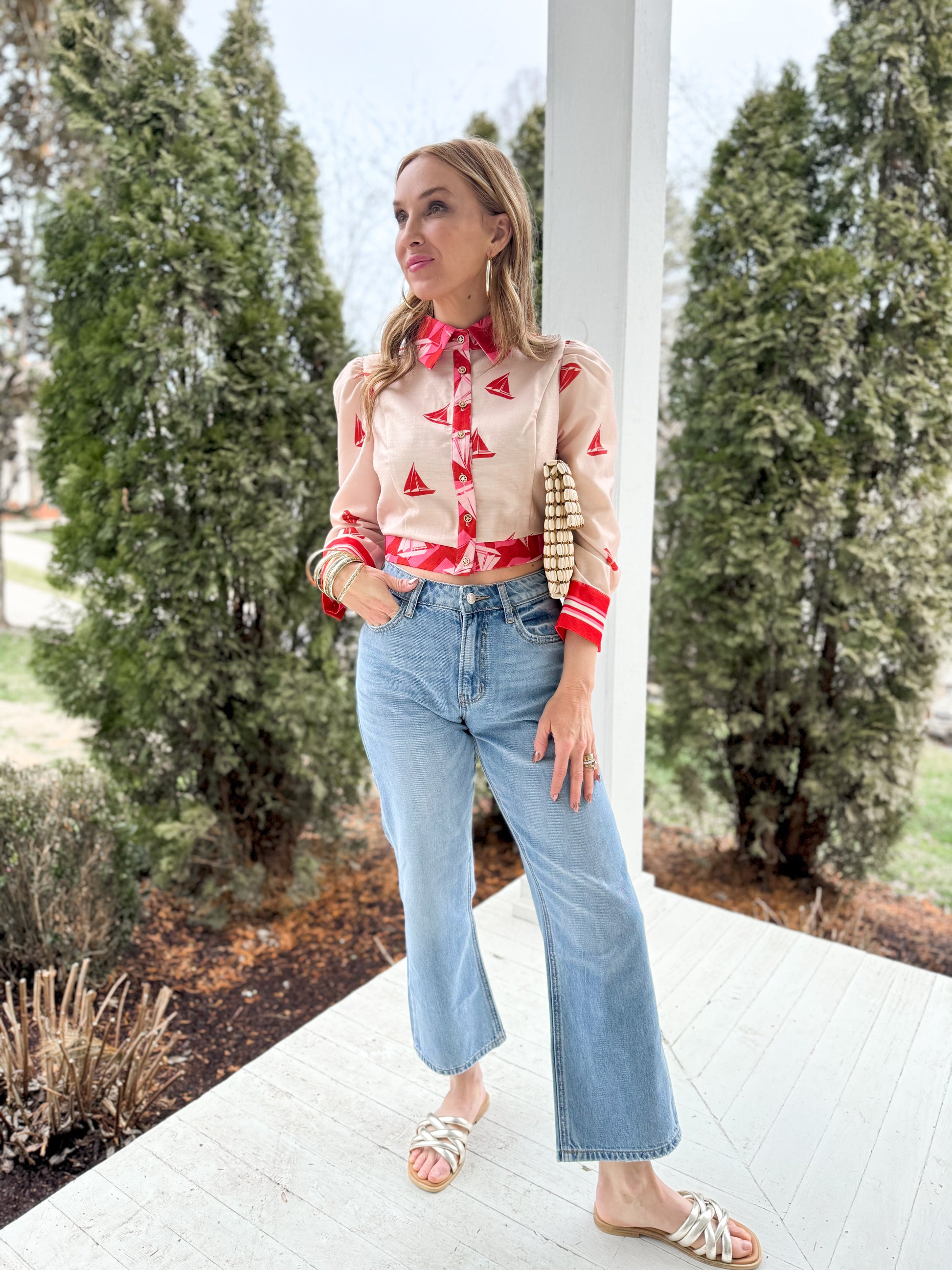 woman standing on porch wearing HIGH RISE straight DAD denim JEANS with sailboat button down long sleeve blouse and sandals 